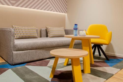 a living room with a couch and two tables at Suites Plaza Hotel & Wellness in Andorra la Vella