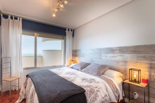 1 dormitorio con cama grande y ventana grande en Bakio Beach VIII by Aston Rentals, en Bakio
