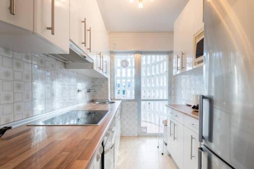 a kitchen with white cabinets and a large sink at Bakio Beach VIII by Aston Rentals in Bakio
