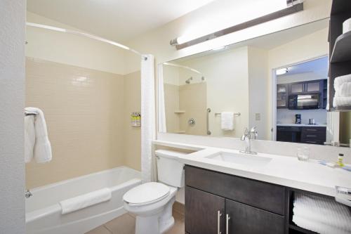 Candlewood Suites Manhattan, an IHG Hotel في مانهاتن: حمام مع حوض ومرحاض وحوض استحمام