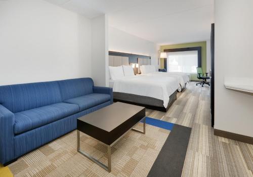 um quarto de hotel com um sofá e uma cama em Holiday Inn Express Hotel & Suites Dublin, an IHG Hotel em Dublin