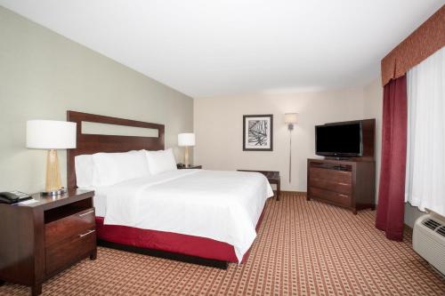 a hotel room with a bed and a flat screen tv at Holiday Inn Express Hotel & Suites Gillette by IHG in Gillette