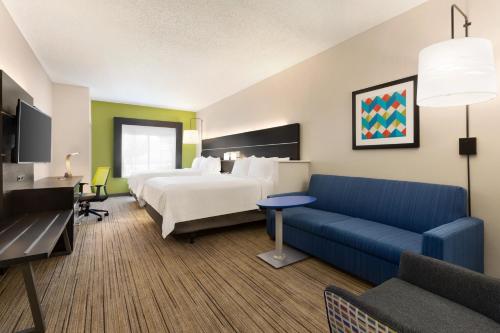une chambre d'hôtel avec un lit et un canapé dans l'établissement Holiday Inn Express Hotel & Suites Shawnee I-40, an IHG Hotel, à Shawnee