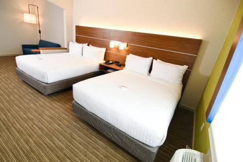 a hotel room with two beds and a chair at Holiday Inn Express Hotel & Suites Port Clinton-Catawba Island by IHG in Port Clinton