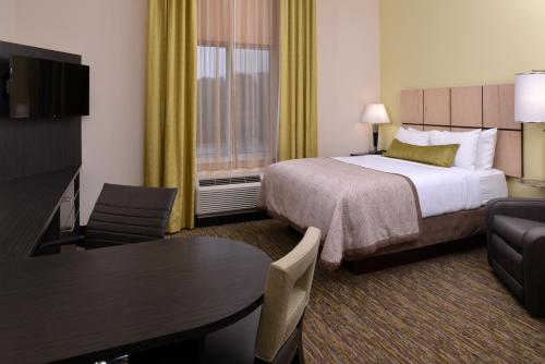 a hotel room with a bed and a table at Candlewood Suites Morgantown-Univ West Virginia by IHG in Morgantown