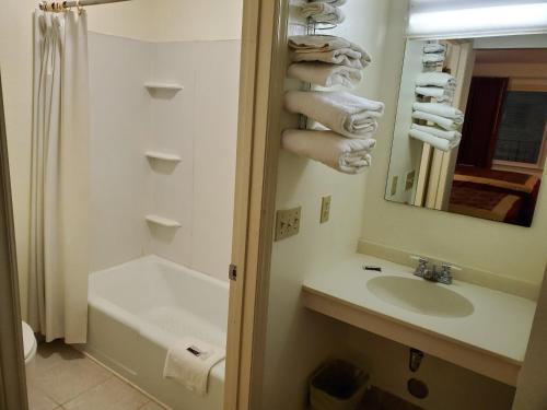 e bagno con lavandino, servizi igienici e vasca. di Elk Inn Motel a Elkin