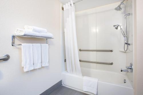 a bathroom with a shower and white towels at Holiday Inn Express Lexington Southwest Nicholasville by IHG in Nicholasville
