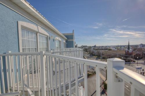 a balcony with white railings and a blue building at Tidelands Caribbean Boardwalk Hotel and Suites in Ocean City
