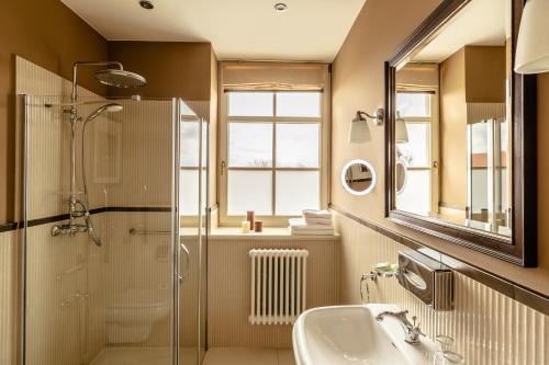 a bathroom with a shower and a sink and a mirror at Zamek Topacz in Wrocław