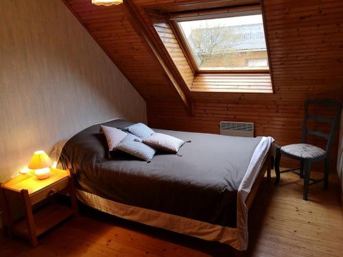 a bedroom with a bed with pillows and a window at Gites de lardanva in Lardanva
