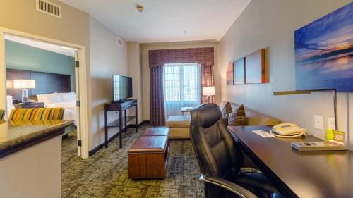 a hotel room with a bed and a desk in a room at Staybridge Suites Houston-NASA Clear Lake by IHG in Webster