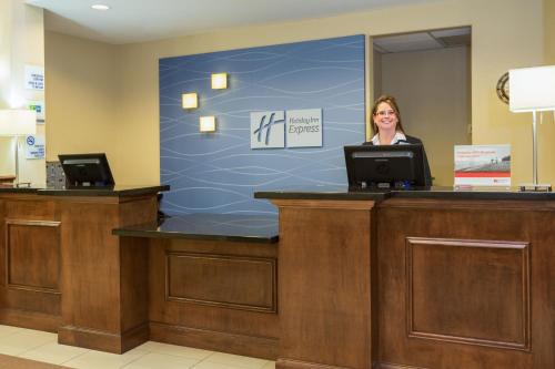 a woman is standing in front of a computer desk at Holiday Inn Express & Suites Moultrie, an IHG Hotel in Moultrie