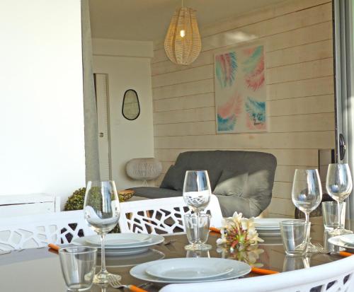 a dining room with a table with wine glasses at LA BOHEME, résidence de 5 appartements avec piscine, vue océan, Petite Ile in Petite Île