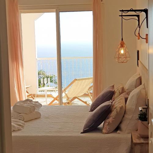 a bedroom with a bed with a view of the ocean at LA BOHEME, résidence de 5 appartements avec piscine, vue océan, Petite Ile in Petite Île