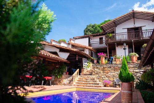 a house with a swimming pool in front of a house at La Serrana Hostal Spa in Socorro