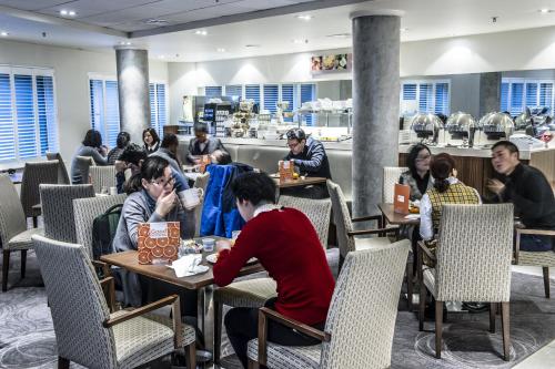 a group of people sitting at tables in a restaurant at Holiday Inn Express Manchester City Centre by IHG in Manchester