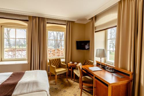a hotel room with a desk and a bed at Zamek Topacz in Wrocław