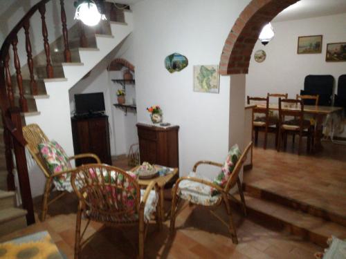 a living room with a staircase and a table and chairs at Casa Marisa in Bibbiena