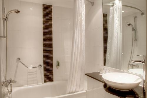 a white bathroom with a sink and a shower at Holiday Inn - Glasgow - City Ctr Theatreland by IHG in Glasgow