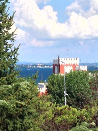 czerwono-biały budynek na szczycie drzew w obiekcie Un nido sul Lago di Garda w mieście Padenghe sul Garda