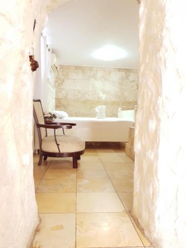 a bathroom with a tub and a chair and a tub and a sink at Lake Mansion in Tiberias