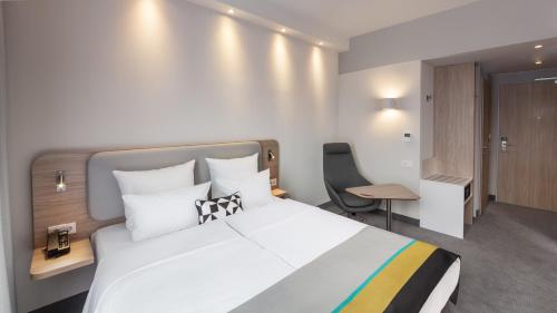 a bedroom with a bed and a desk and a chair at Holiday Inn Express Munich - City East by IHG in Munich