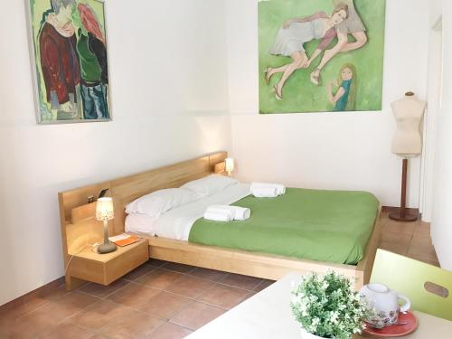 ein kleines Schlafzimmer mit einem Bett und Gemälden an der Wand in der Unterkunft B&B La Corte in SantʼAntimo