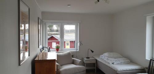 sala de estar con sofá, silla y ventana en Lövnäs - Eget Hus utan andra gäster en Sörsjön