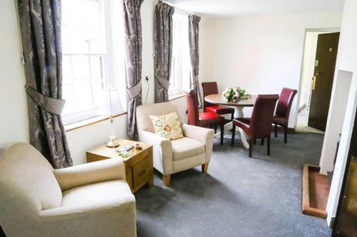a living room with two chairs and a table at Little Easton Manor in Great Easton