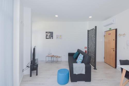 a living room with a black couch and a tv at Near The Beach Apartments in Matosinhos
