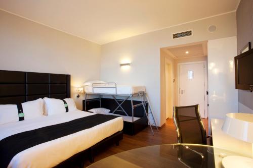 a hotel room with a bed and a glass table at Holiday Inn Genoa City by IHG in Genova
