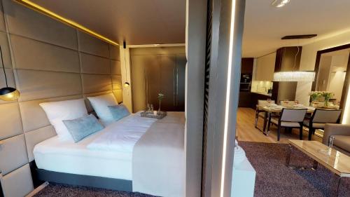 - une chambre avec un grand lit blanc et une salle à manger dans l'établissement White Pearl Apartment 0.03, à Timmendorfer Strand