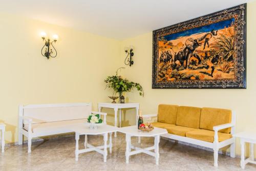 a living room filled with furniture and a painting on the wall at Oasis Studios in Malia