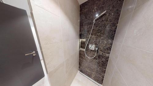La salle de bains est pourvue d'une douche avec une porte en verre. dans l'établissement White Pearl Apartment 0.03, à Timmendorfer Strand