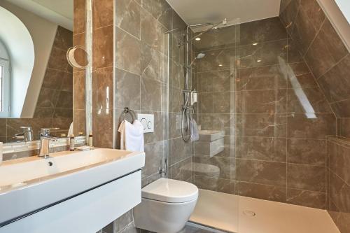 a bathroom with a shower and a toilet and a sink at Régence Etoile in Paris