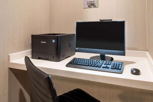 a desk with a computer monitor and a keyboard and mouse at Wingate by Wyndham Denver Airport in Denver