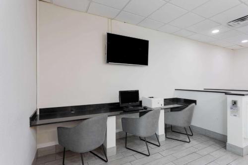 a room with a desk with a laptop and chairs at Wyndham Garden Tallahassee Capitol Near FSU in Tallahassee