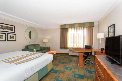 a hotel room with a bed and a flat screen tv at La Quinta by Wyndham Denver Southwest Lakewood in Lakewood