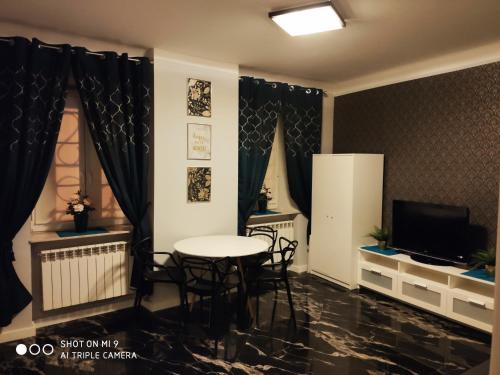 ein Esszimmer mit einem Tisch und Stühlen sowie einem TV in der Unterkunft Apartament Nina in Warschau