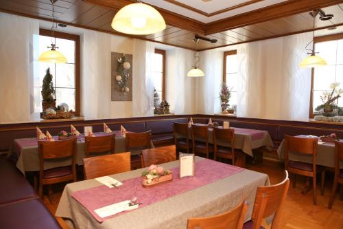 a dining room with tables and chairs and windows at Gasthof Hotel Adler Inneringen in Inneringen-Hettingen