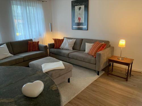 a living room with a couch and a table at Charmantes Haus mit zwei Ferienwohnungen und großem Garten in Aventoft - Enjoy! in Aventoft