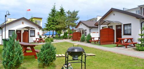 a backyard with a grill and some houses at Baltic Resort Darłówko - Domek nr 2 in Darlowko