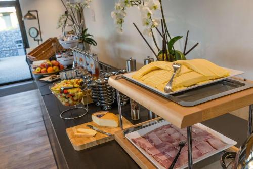 a breakfast table with meats and cheese on a counter at Golden Lakes Hotel in Boussu-lez-Walcourt