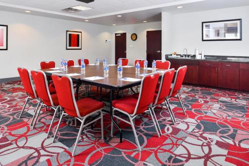 a conference room with a table and red chairs at Holiday Inn Express Canandaigua by IHG in Canandaigua