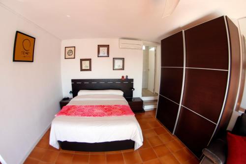 a bedroom with a bed with a red blanket on it at Villa Teresa in Agua Amarga