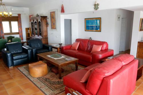 a living room with a red couch and chairs at Villa Teresa in Agua Amarga