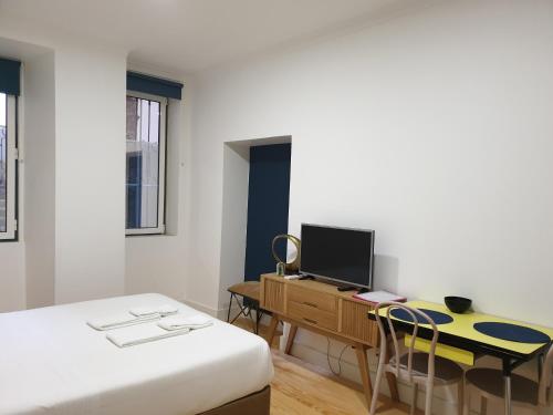 um quarto com uma cama e uma secretária com um computador em Alfama Apartments Services em Lisboa