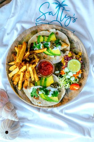 a plate of food with a sandwich and french fries at Salty's Kitesurf Village in Kilifi