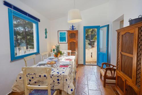 a dining room with a table and a blue door at Casa di Cri in San Vito lo Capo