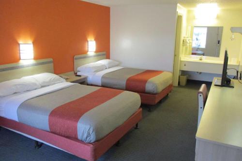 a hotel room with two beds and a mirror at Travelodge by Wyndham Lansing in Lansing